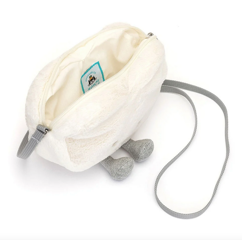 Top view of plush cream heart bag with the zipper opened and looking into the compartment.