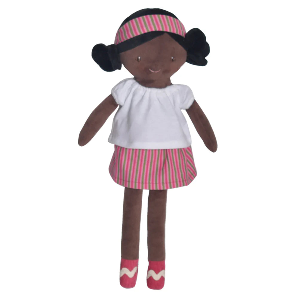 Plush doll Amy with black hair and brown skin standing wearing a plaid skirt and matching headband with white shirt.