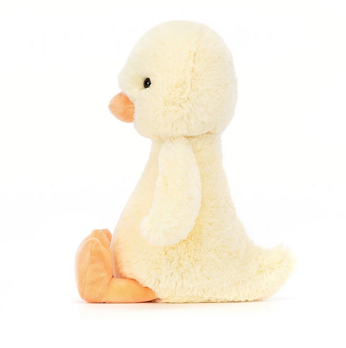 Side view of Bashful Duckling with soft pale yellow fur, and orange beak and feet. 