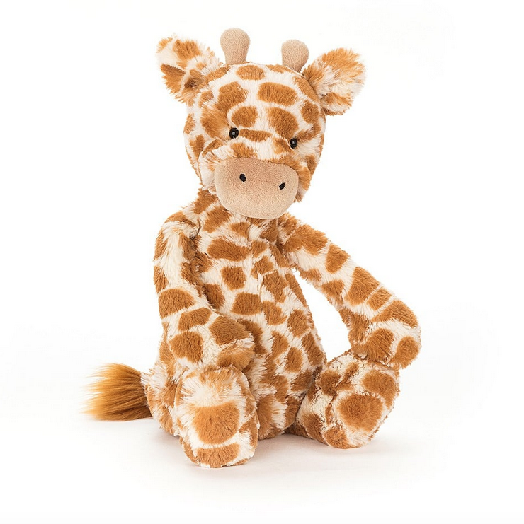 Medium plush giraffe with orange and white spotted fur fuzzy ears and little horns at the top of it's head. 