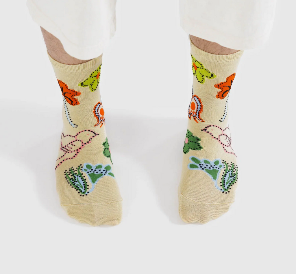 A set of feet wearing the Birds Crew Socks.