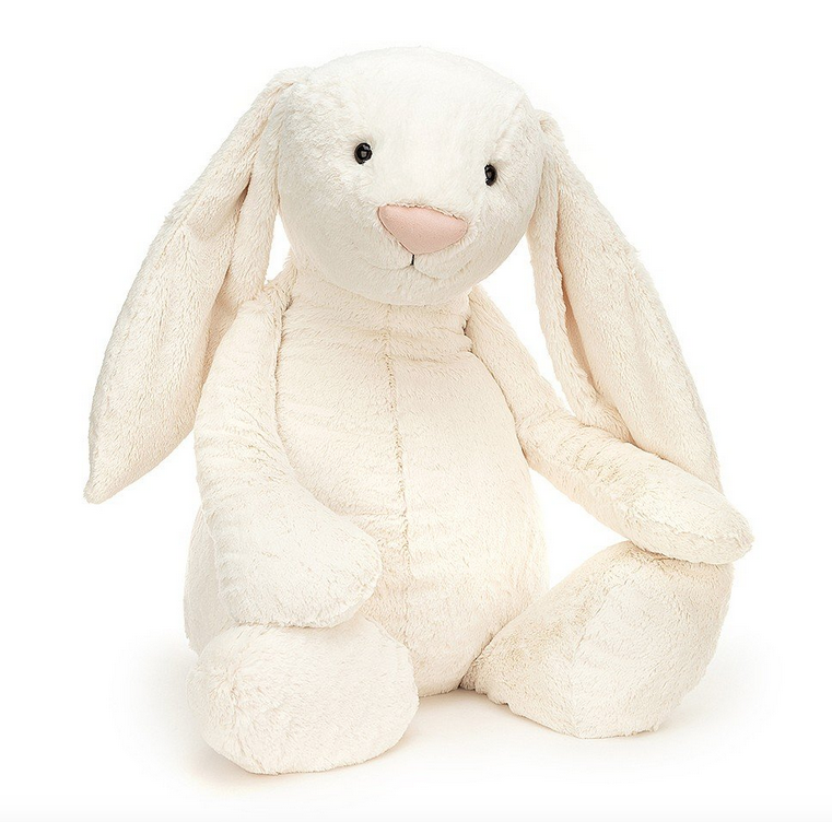 Plush cream colored bunnysitting up and facing forward. It has long lop ears and a pink nose. 