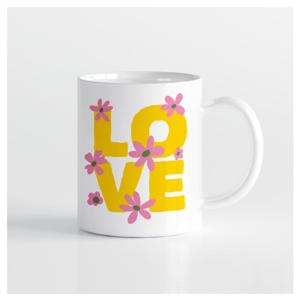 White mug with purple flowers and yellow letters that read "LOVE"