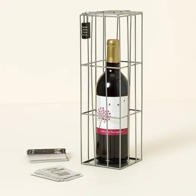A bottle of wine locked in the cage with clue cards on the table in front.