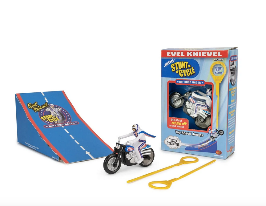 Mini stunt cycle, mini stunt ramp, and an extra rip cord set up in front of the box all are packaged in.