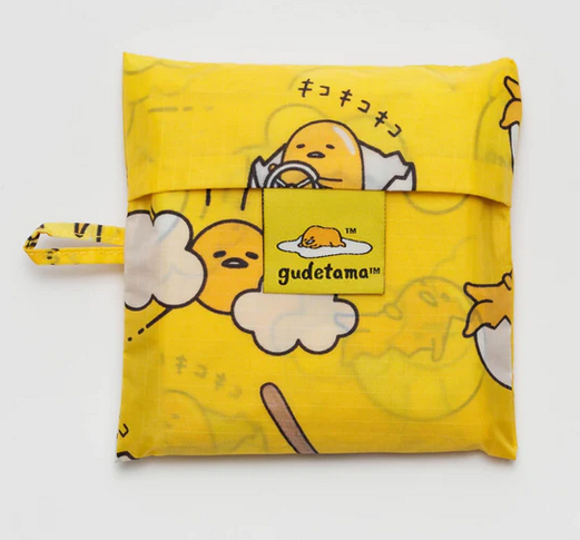 The Standard Baggu in the Gudetama print folded in the included pouch.