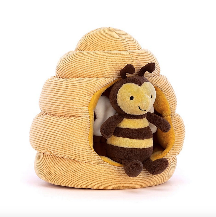 Plush honeycomb with a brown and yellow plush bee sitting inside.