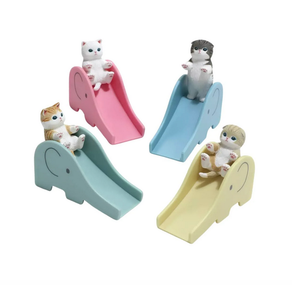 Each cat on a slide figure that it is possible to get from this blind box series. An orange tabby on a green slide, a white kitty on a pink slide, a grey and white kitty on a blue slide and a calico on a yellow slide.