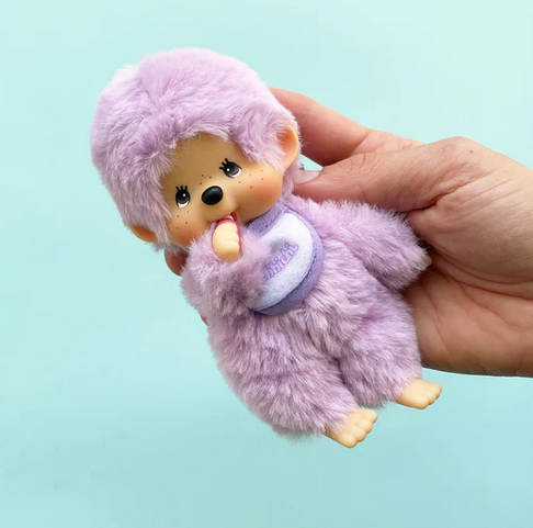 The purple Monchichi Colorful Beanie plush doll being held in a hand. 