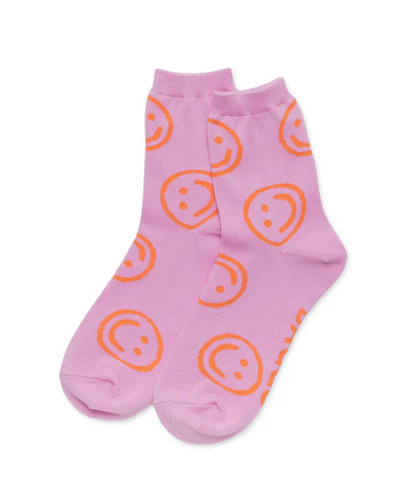 A pair of crew socks that are peony pink with orange smiley faces all over them.