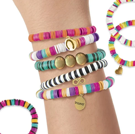 Several bracelets made with the kit and being worn on someones wrist. There are orange and pink, black and white, black and turquoise, as well rainbow beaded bracelets. 