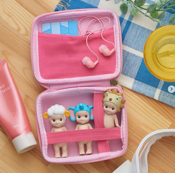 The Sonny Angel carrying case opened with three figures and earbuds inside. 