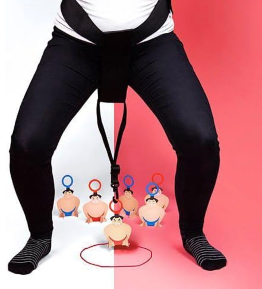 Picture of a person ready to play Sumo Squats. With the belt attached around their waist and picking up the Sumo wrestler game peices. 