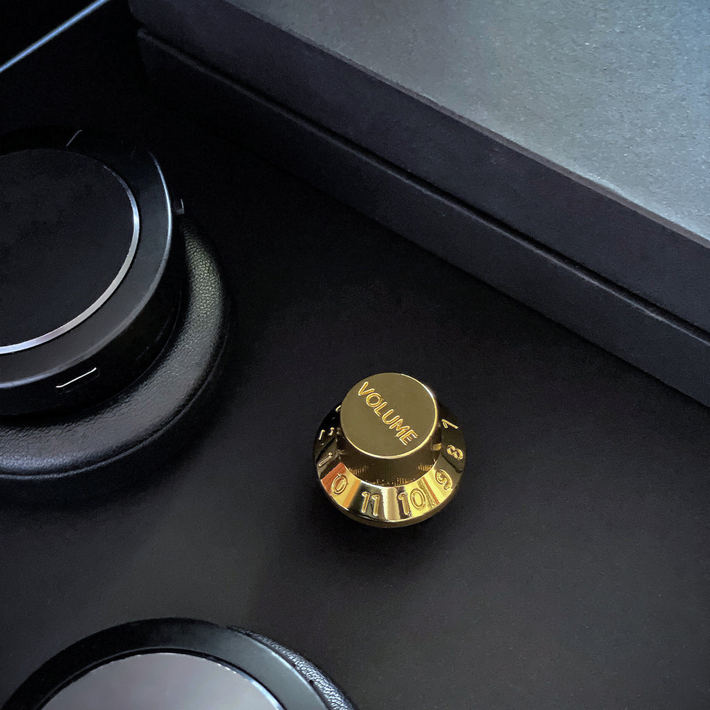 Gold metal knob with "volume and numbers" on a table. 