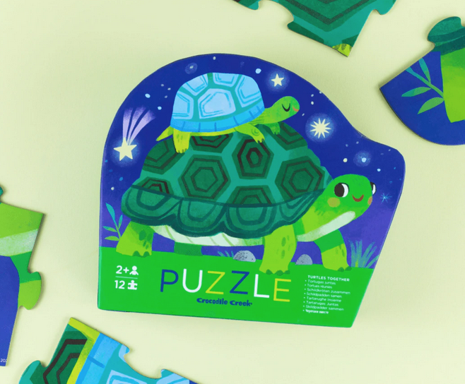 Shaped puzzle b ox with illustrated image of two turtles on the cover.