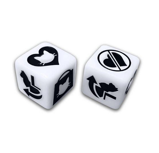 Close up view of the die used to play We Love Cats, the die have imges of cars, hearts, and other actions to be taken while playing the game. 