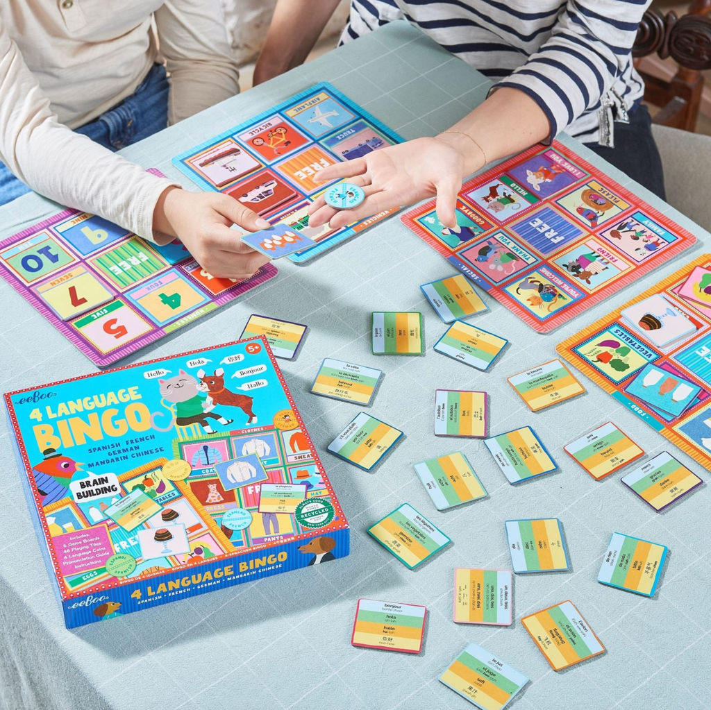 People playing 4 Language Bingo game on a table.