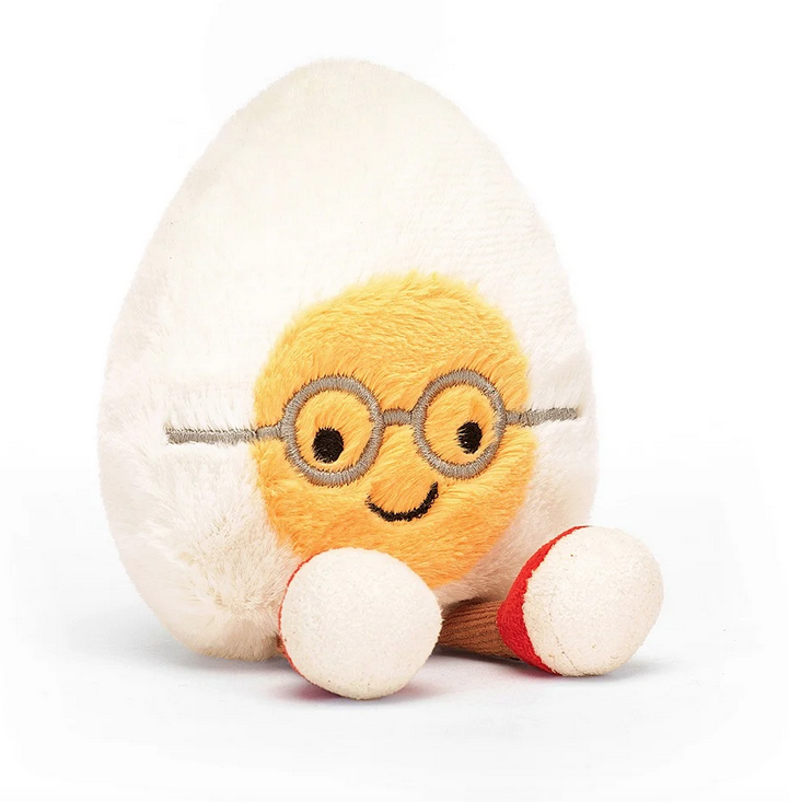 The Amuseable Boiled Egg Geek sitting with it's feet in front and wearing glasses. 