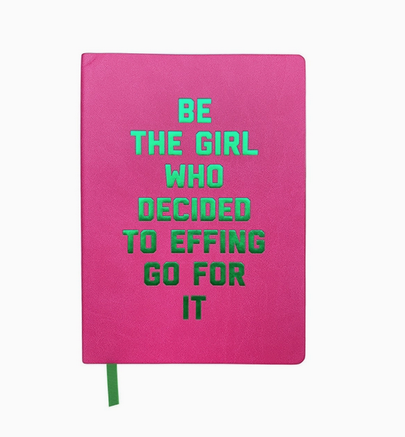 Hot pink journal cover with foiled green lettrs that read "Be the girl who decided to effing go for it" A green ribbon place holder is peeking out from the bottom of the journal. 