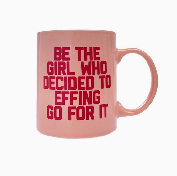Light pink ceramic mug with dark pink lettering that reads "Be the girl who decided to effing go for it"