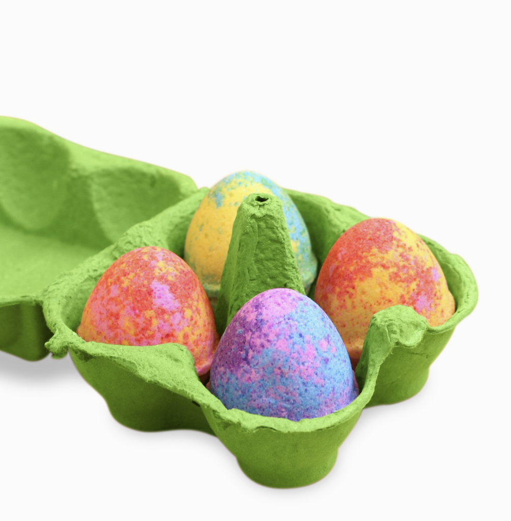 Set of 4 multicolored egg shaped bath bobbs in a green cardboard package.