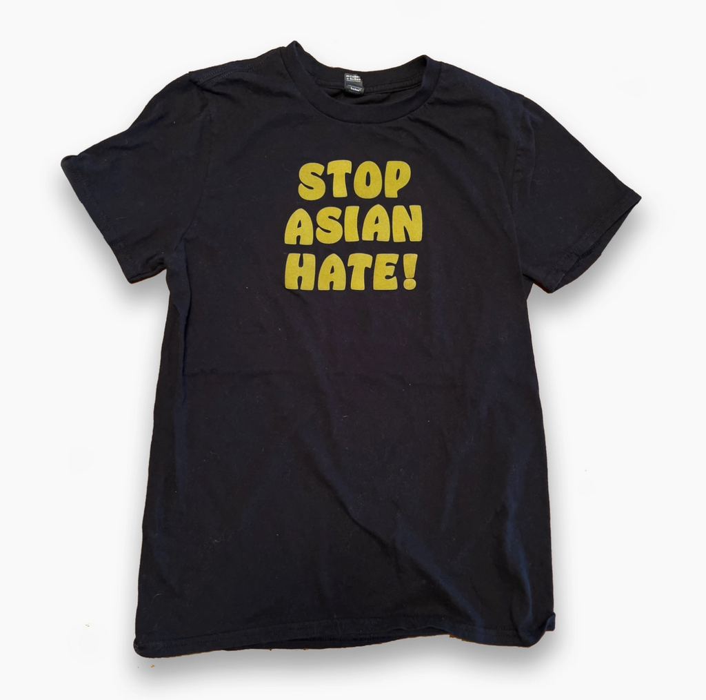 Black shirt with yellow text that reads stop Asian hate!