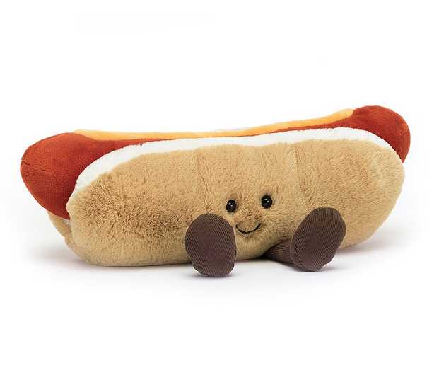 Amuseable Hot Dog plush wearing a sweet smile and sitting with it's legs out in front of it. 
