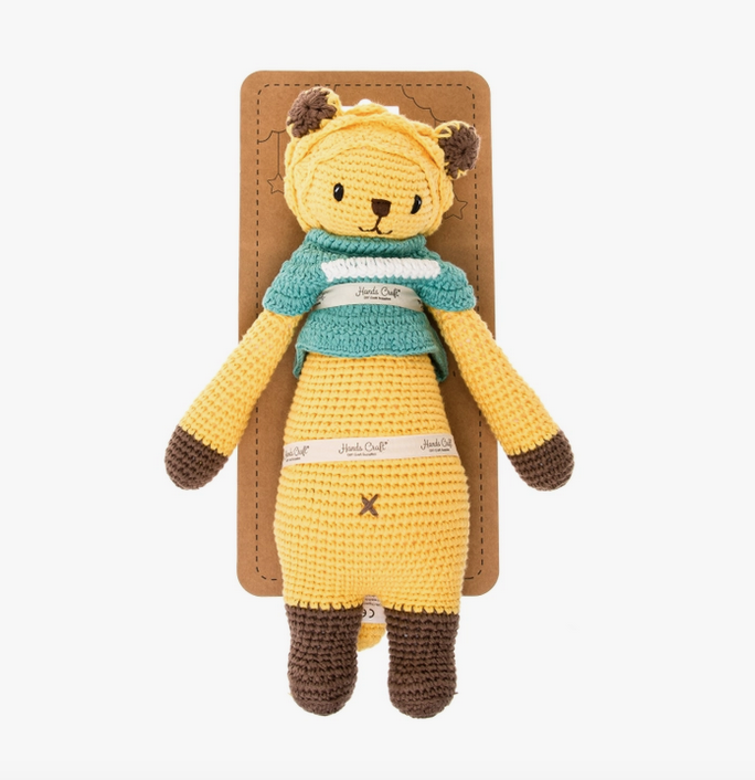 Leo the crochet doll tied with a ribbon to a recyclable cardboard hangcard. 