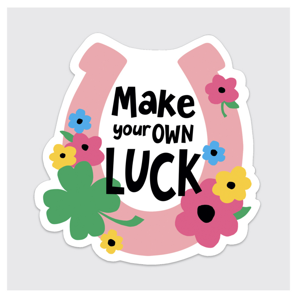 Diecut pink horseshoe sticker with flowers and black text that reads "Make Your Own Luck."