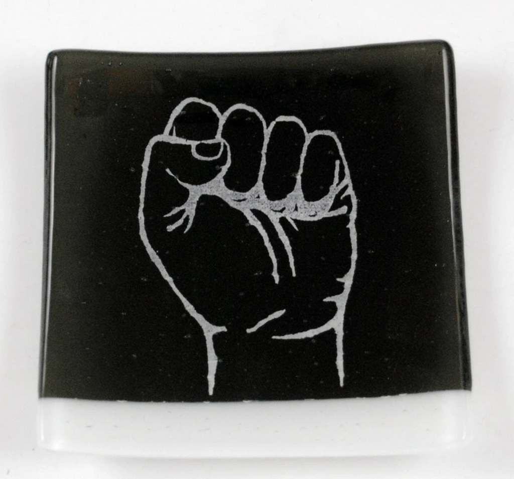 This catch-all features the hand symbol for Resist screen printed in white enamel onto transparent charcoal glass, paired with a wispy white stripe, then fused in a kiln to about 1400 degrees. 