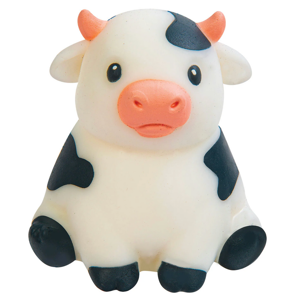 A pudgy white and black cow shaped squishy toy. 