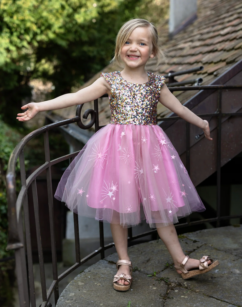 A child wearing the A Star Is Born Sequin dress standing on a balcony. 