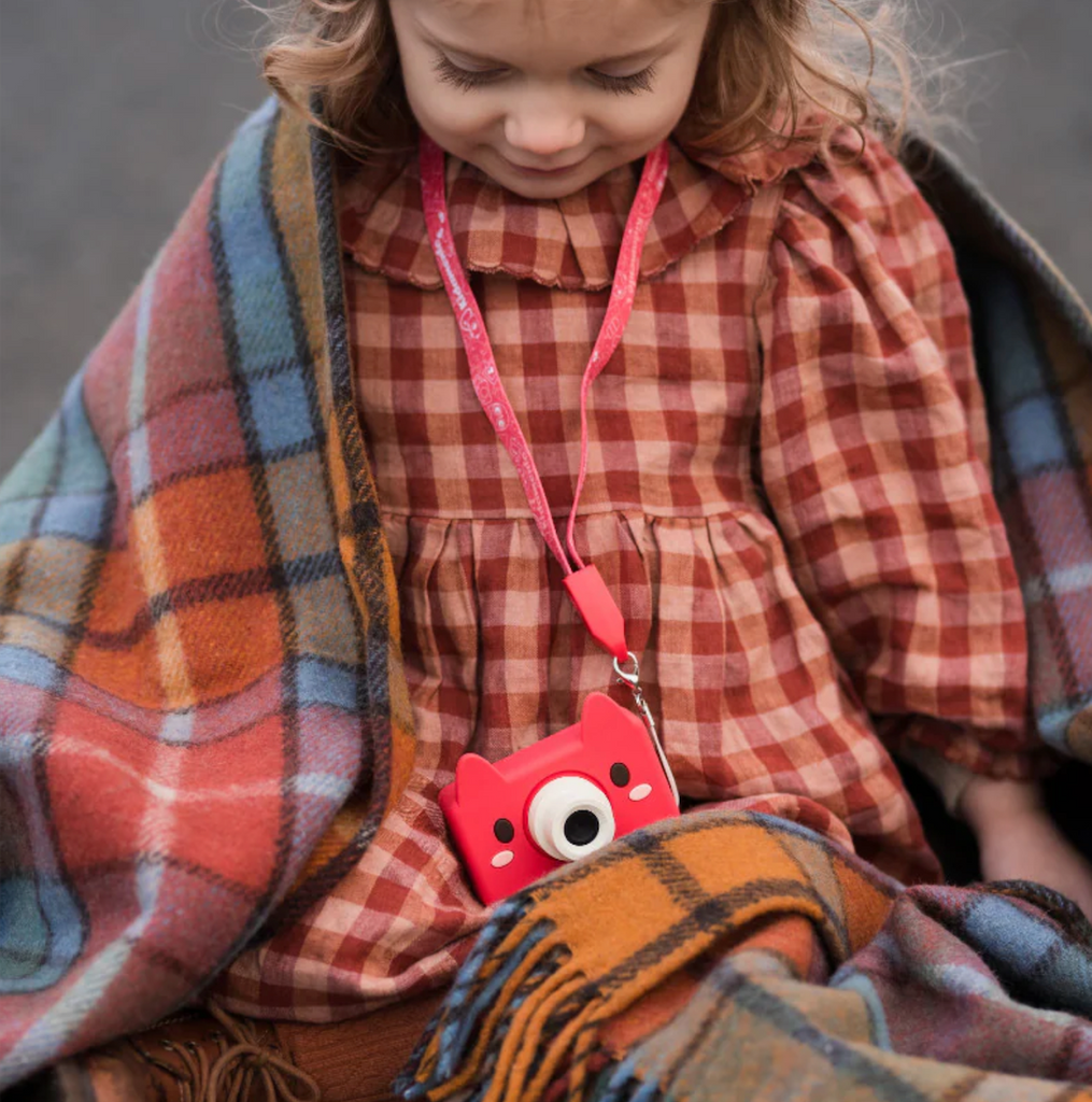 A young child using the lanyard strap to keep the Akito the Fox camera around her neck. 