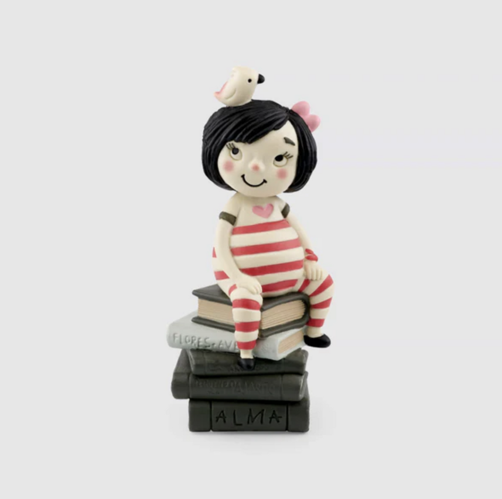 Alma Tonie figure is a little girl with dark hair wearing a red and white striped outfit sticking on a stack of books with a bird on her head.