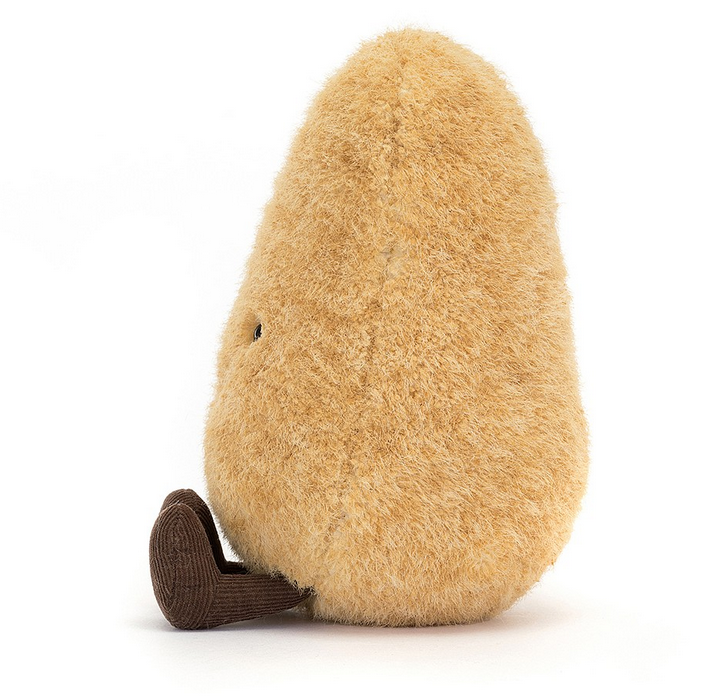 View from the side of the plush potato in a seated position with it's brown boots stretched out in front of it. 