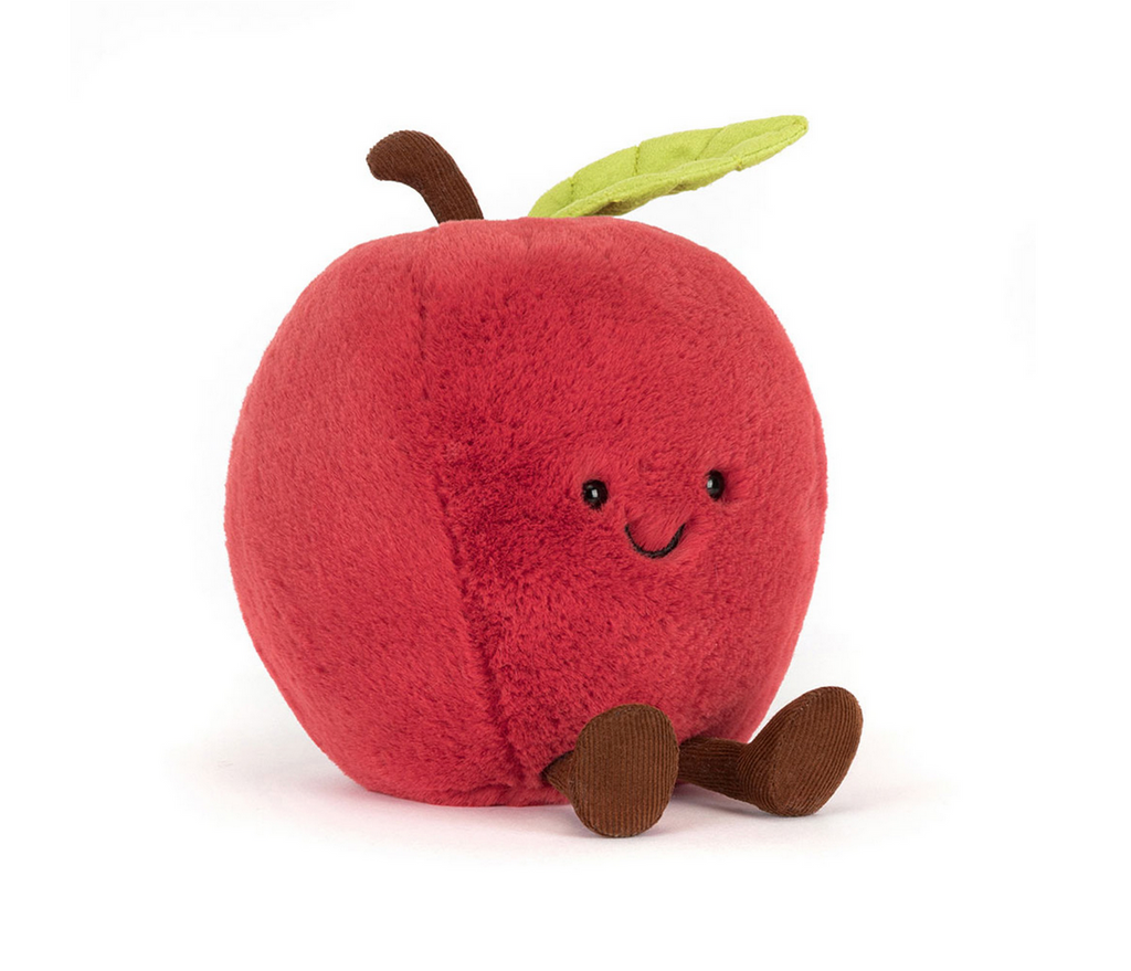 Plush toy shaped like a red apple with a smiling face on a white background