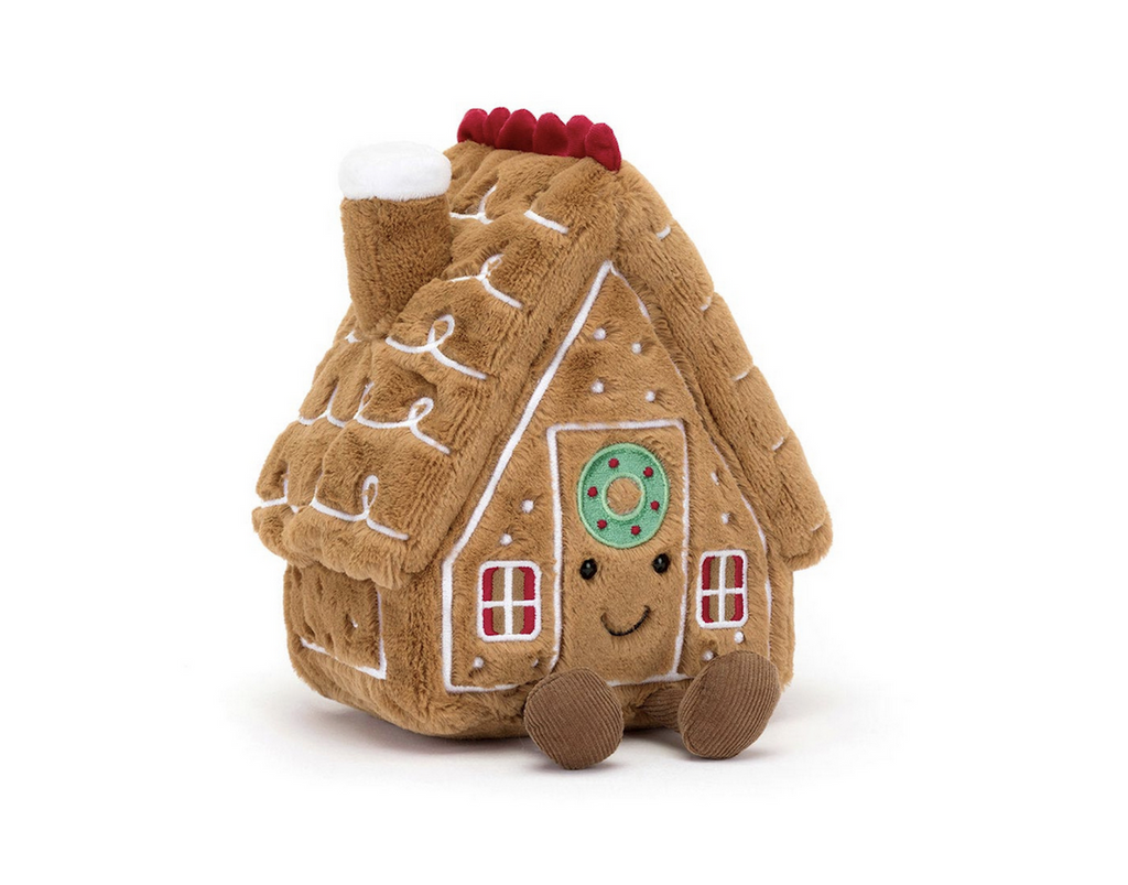 Brown plush decorated gingerbread house on a white background.