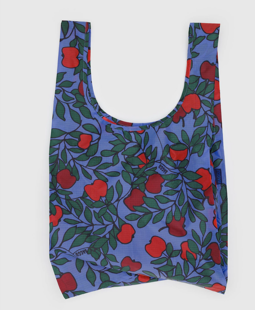 Standard Baggu reusable shopping bag with a vibrant red apple tree pattern on a bright blue background. 
