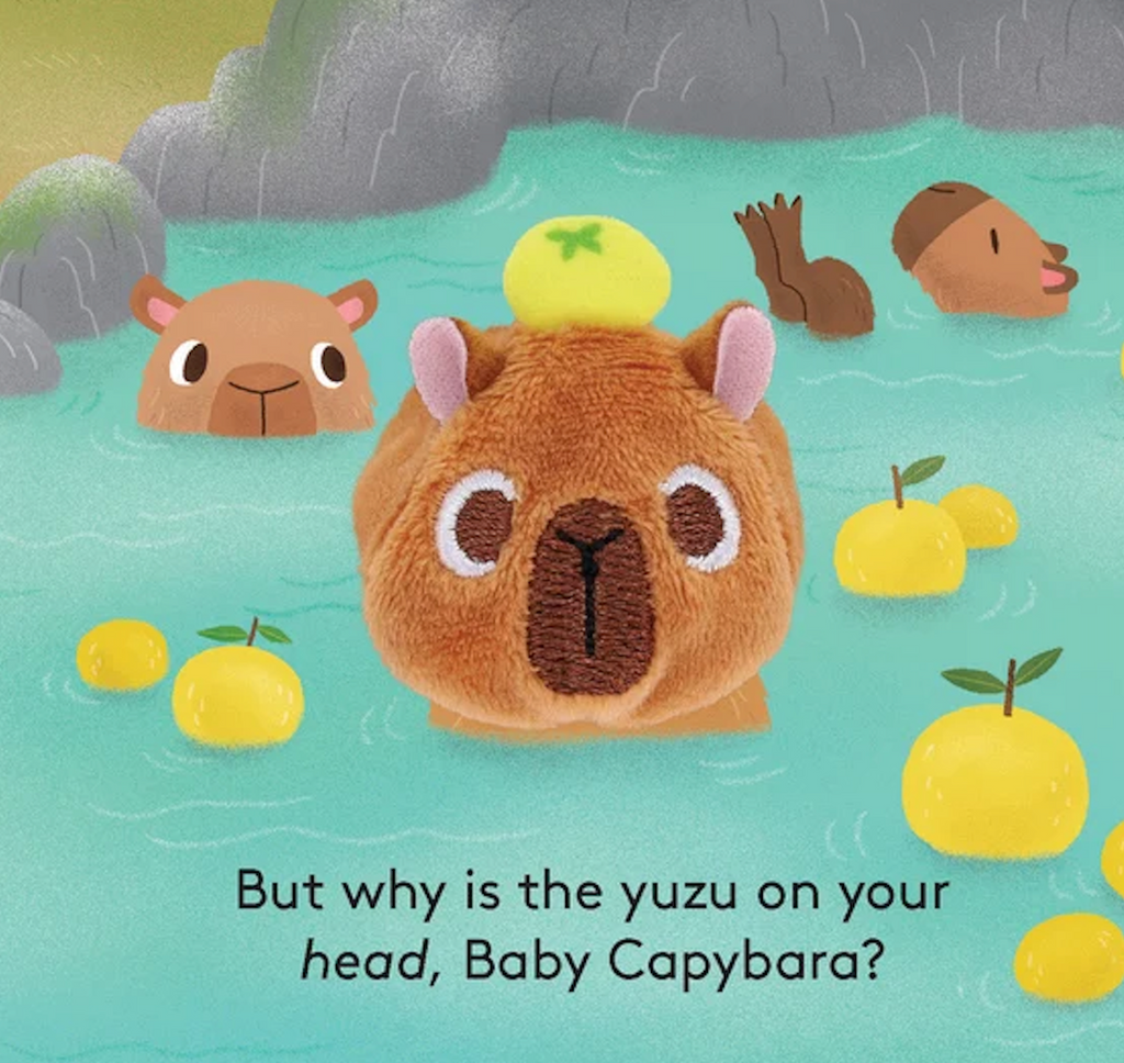 Interior page from Baby Capybara Finger Puppet book with capybars swimming with yuzu in the water and on the main Baby Capybara's head. 