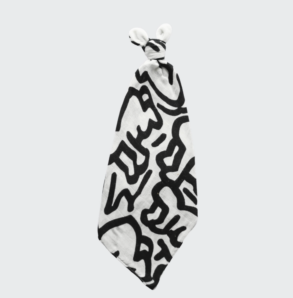 Black and white baby soother featuring a Keith Haring "baby print on a white background.