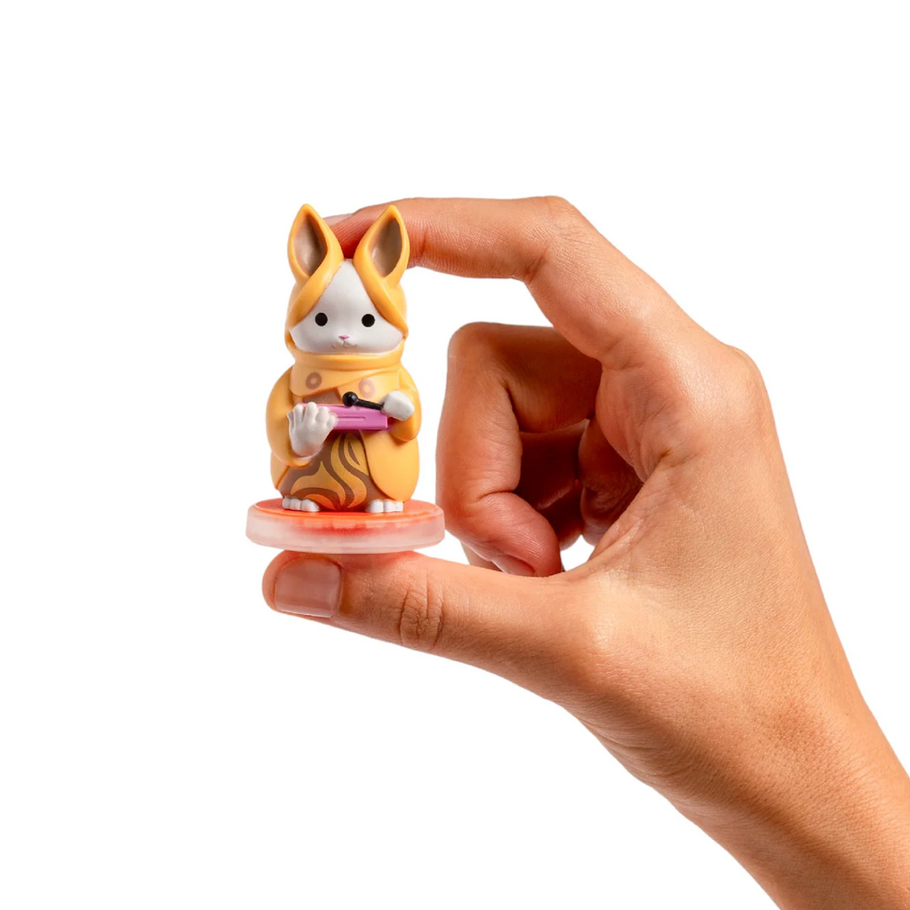 Bacca Fantasimo a small figurine of a white rabbit dressed in a yellow robe holding an instrument. 