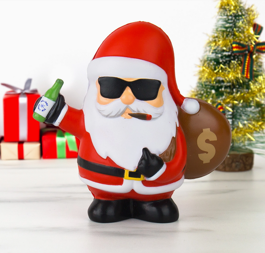 Sqush Santa Claus toy with sunglasses, cigar, and money bag in front of Christmas tree and presents.