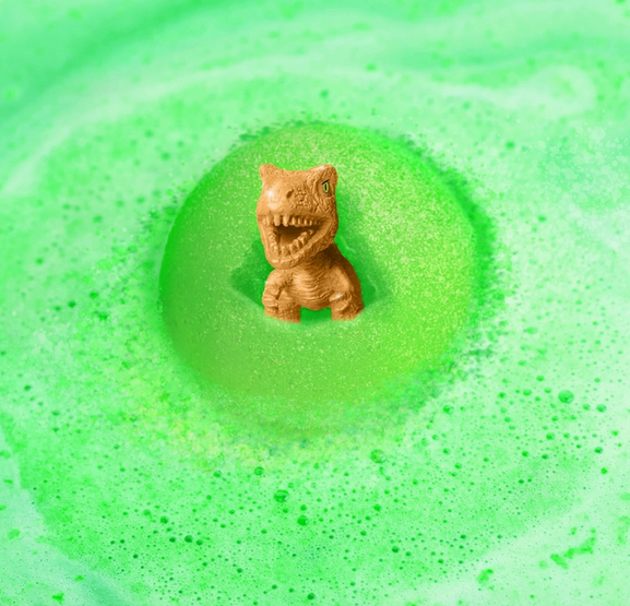 The secret golden dino emerging from a green bath bomb in water. 