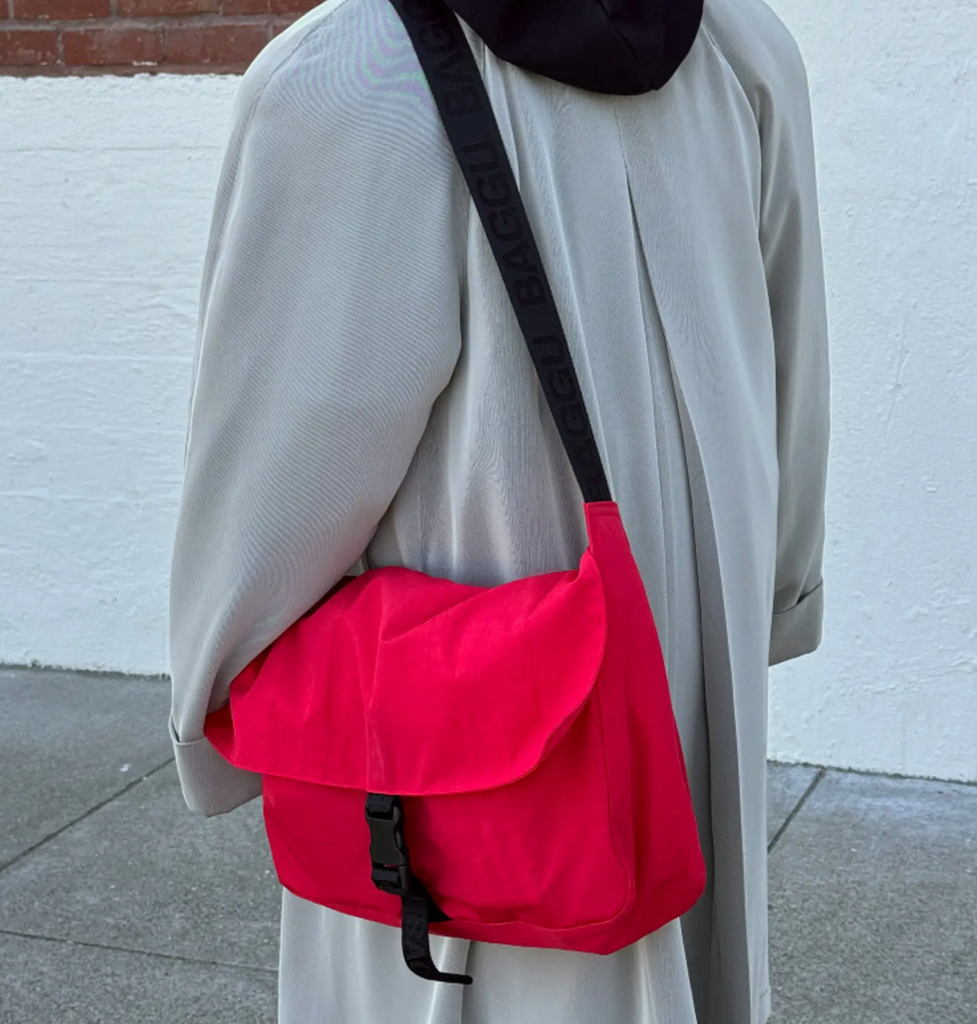 Baggu Candy Apple messenger bag worn over the shoulder.