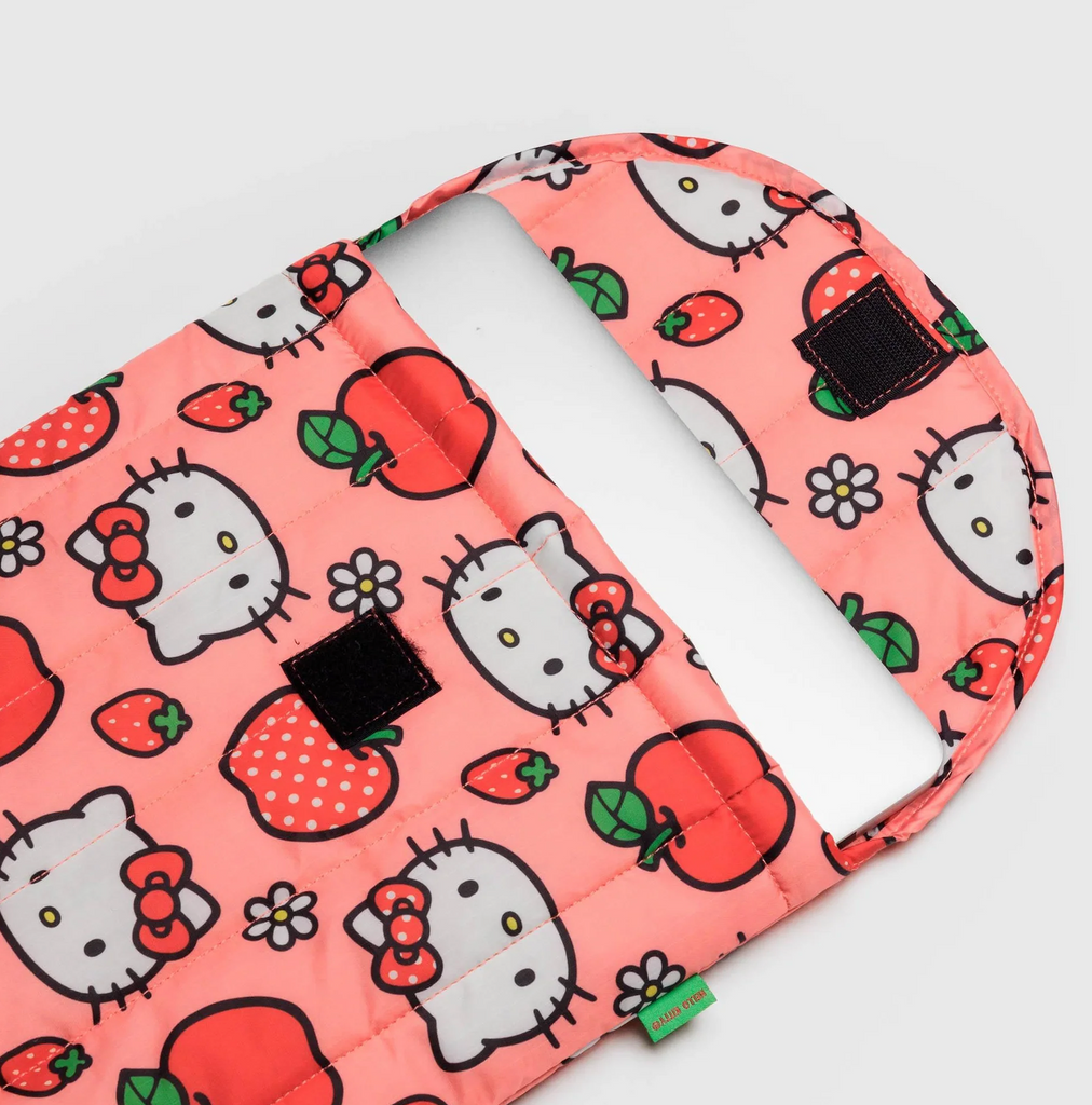 Laptop sleeve by Baggu in Hello Kitty Apple print opened to show laptop it's holding and velcro closure. 