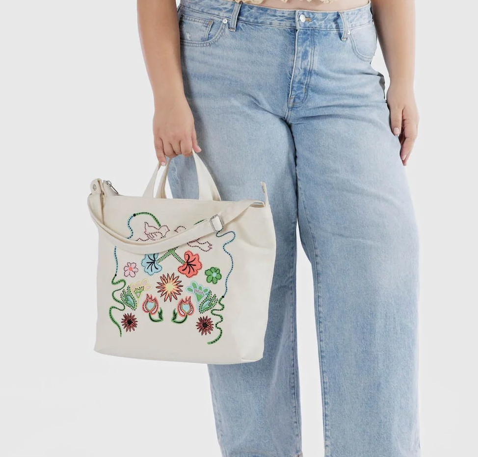 The Baggu Horizontal Zip Duck Bag being held by the handles. 