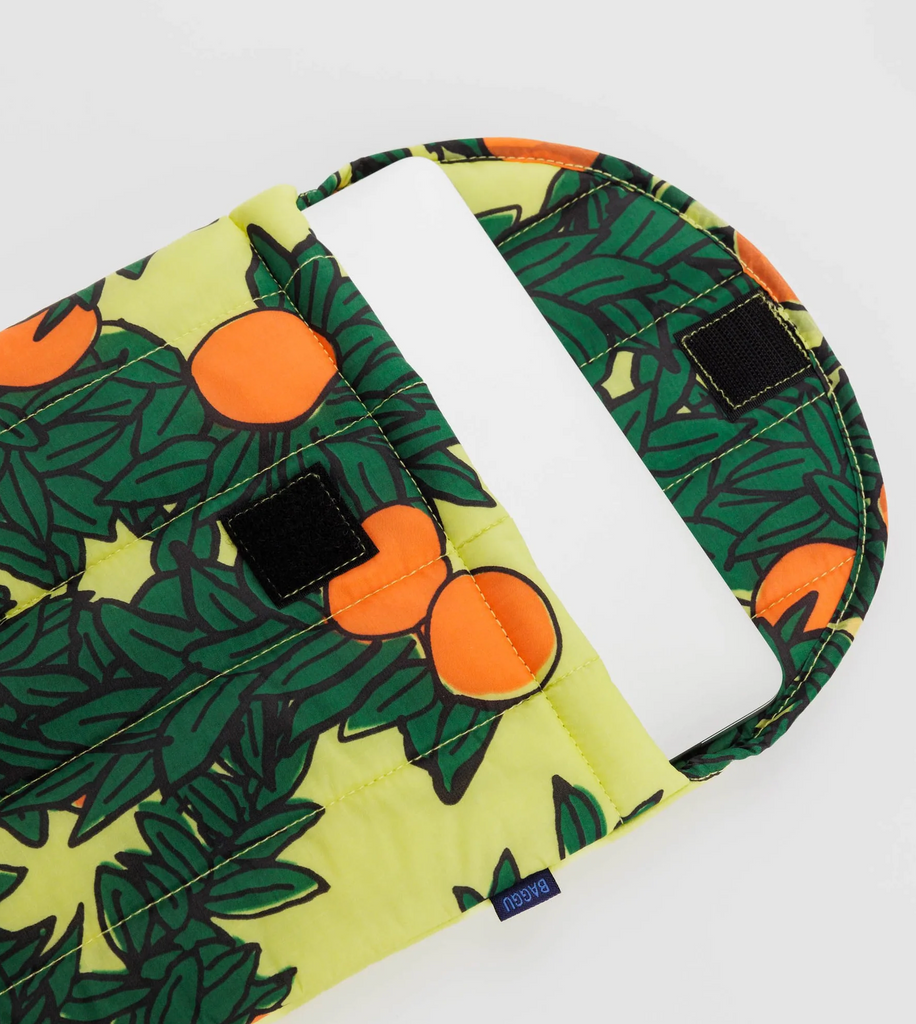 Baggu puffy laptop sleeve in yellow orange tree print open ed showing a laptop. 