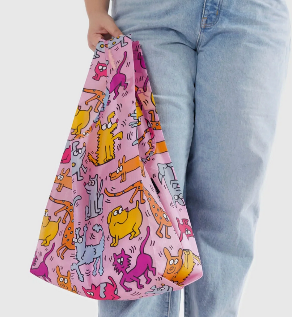 Baggu Keith Haring standard bag full of stuff and being held by it's handles. 