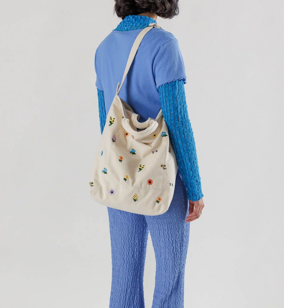 Ditsy Floral patterned Baggu Duck bag slung over the shoulder of a person. 