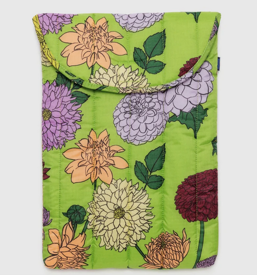 Puffy laptop sleeve with multicolored dahlia blooms on a bright green background. 